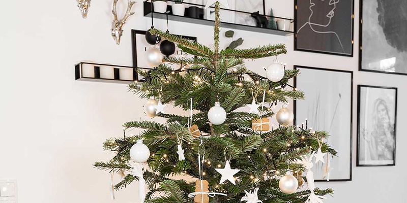 Geschmückter Christbaum vor einer Wand mit Bildern und Dekoration  