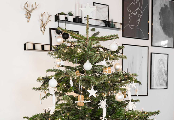 Weiß geschmückter Christbaum mit einer Spitze aus einem weißen Stern