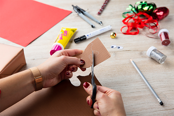 Wellkarton wird mit einer Schere geschnitten