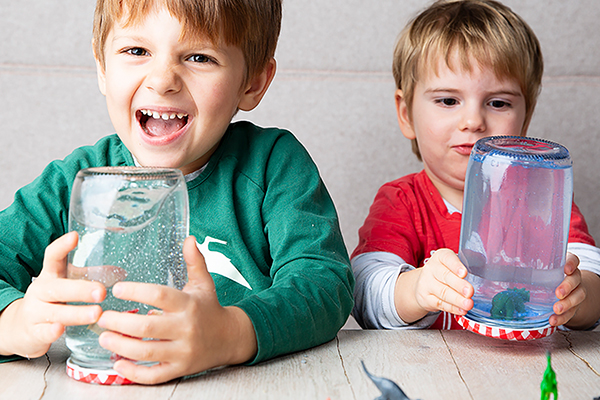 Zwei Buben mit den gelbstgebastelten Glitzerkugeln.