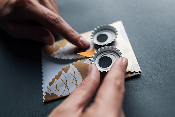 Gebastelte Eule aus Papier und Bierstöpseln.