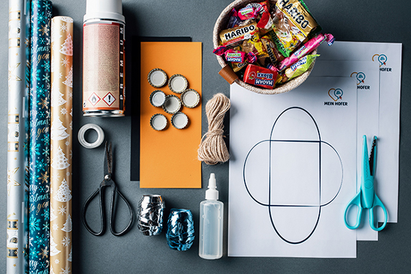 Bastelutensilien wie Kleber, Schere und Geschenkpapier