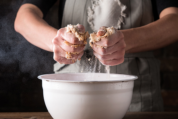 Zutaten werden in einem Topf vermengt und geknetet.