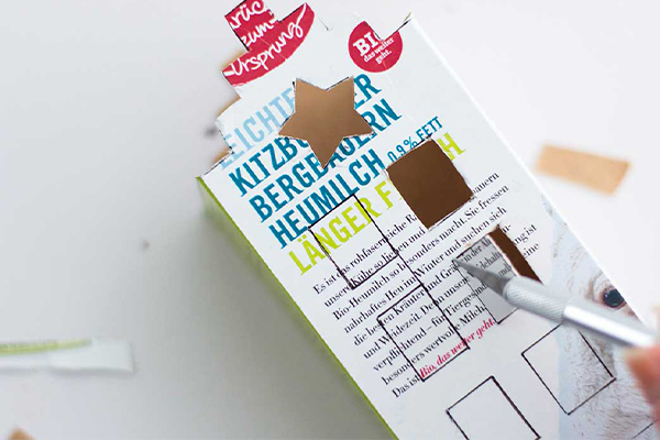 Milchkarton wird mit Cuttermesser zugeschnitten