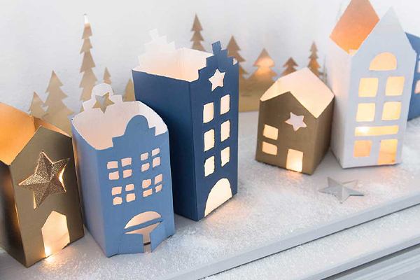 Häuser aus Milchkartons in verschiedenen Blautönen und Gold.