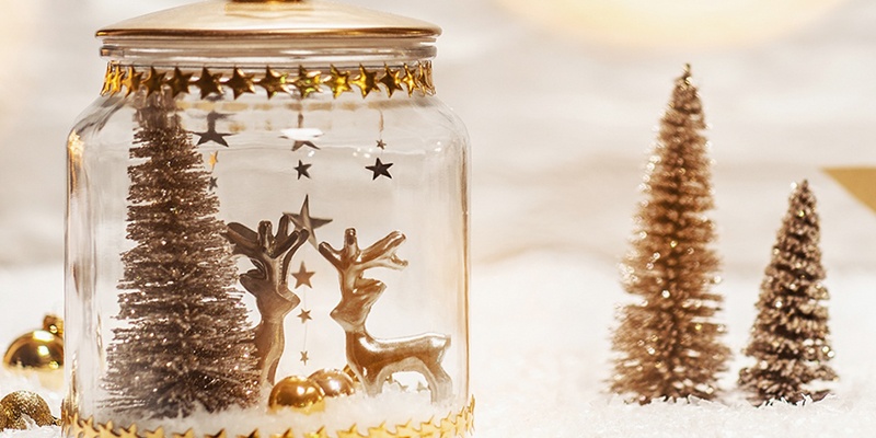 Weihnachtliche Schneekugel mit einer Winterwelt in Gold 