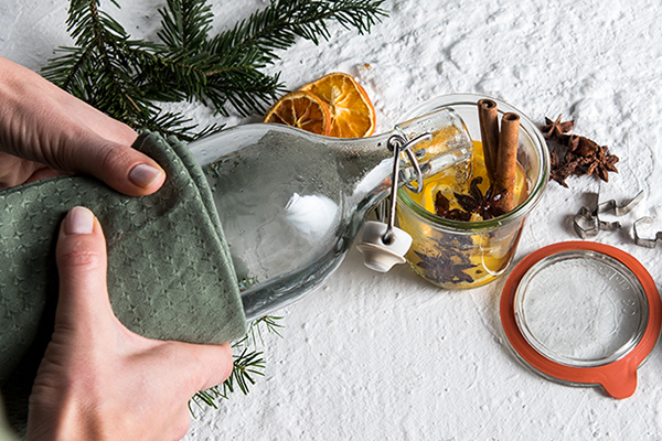 In ein Glas mit Gewürzen wird warmes Wasser geleert