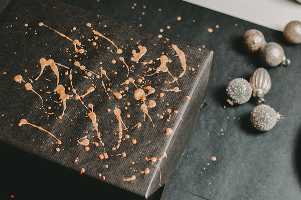 Schwarzes Paket mit goldenen Farbsprenkel.