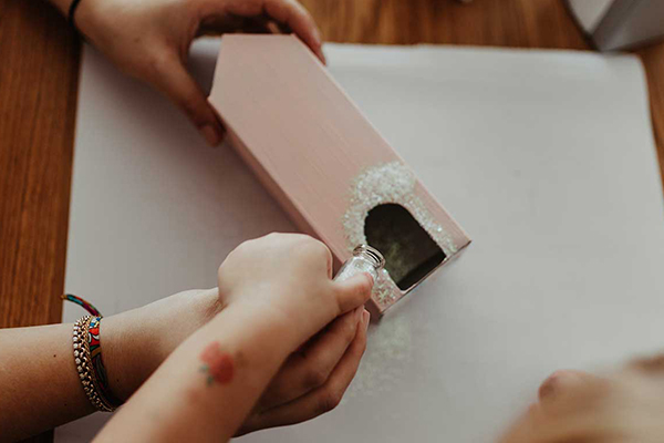 Glitzer wird auf Getränkekarton gestreut