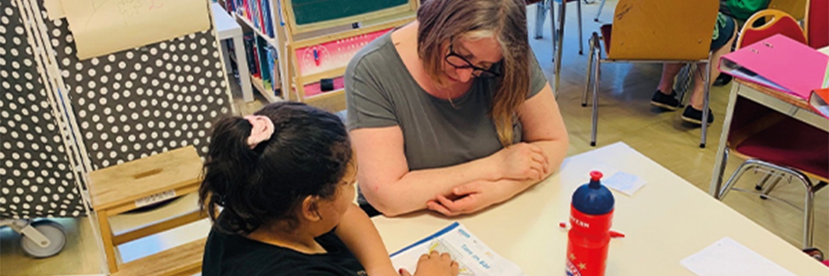 Frau lernt mit einem Mädchen an einem Tisch