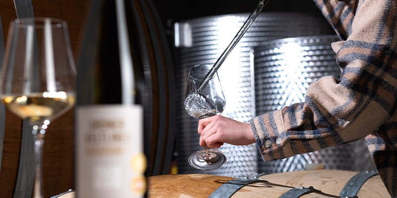 Weißweinglas und Weinflasche mit Etikette von Franz Anton Mayer