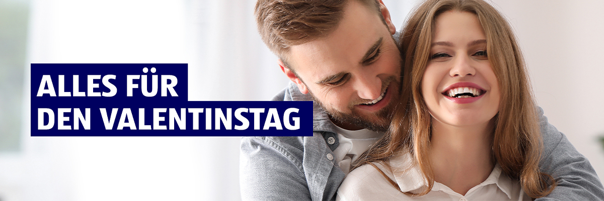 ALLES FÜR DEN VALENTINSTAG. Ein Paar, welches sich umarmt. Umgeben von herzförmigen Luftballons.