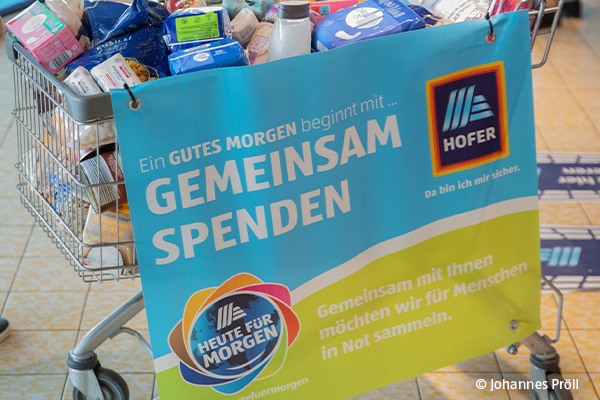 2 Frauen stehen vor gefüllten Einkaufswagen