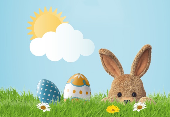 Osterhase mit braunem Fell hinter grünem Gras, zwei Ostereiern und weißen Blumen.