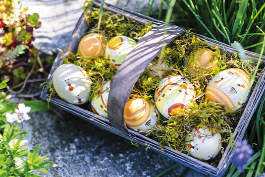 Ein Körbchen ist gefüllt mit Moos und Ostereiern.