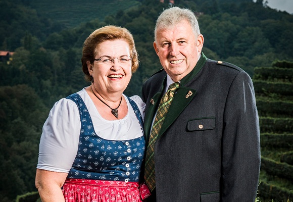 Familie in Tracht vor Weinbergen
