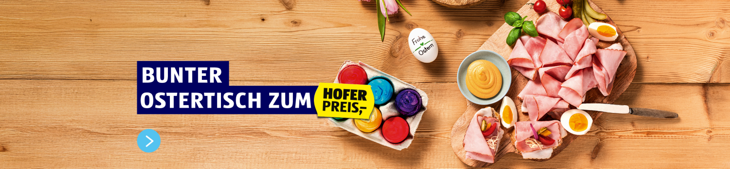 Bunter Ostertisch zum HOFER Preis. Auf dem Bild ist eine gedeckter Tisch mit einem Gourmet Butterbrioche, Ostereiern, Antipasti und vielem mehr.