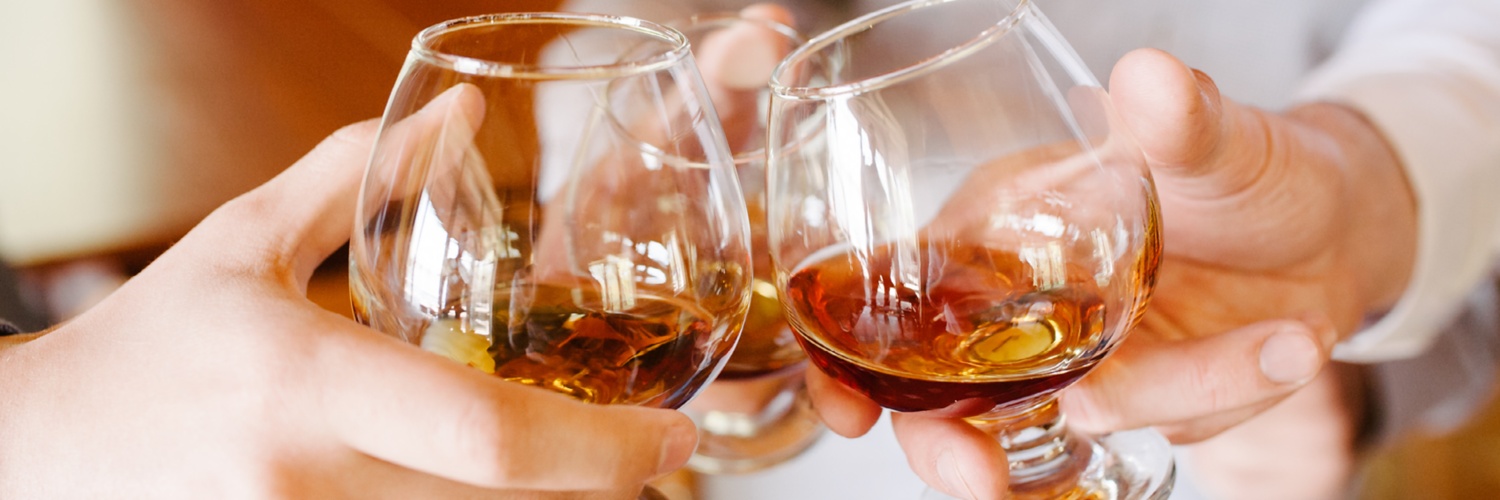 Gläser mit Spirituosen gefüllt, stoßen zusammen