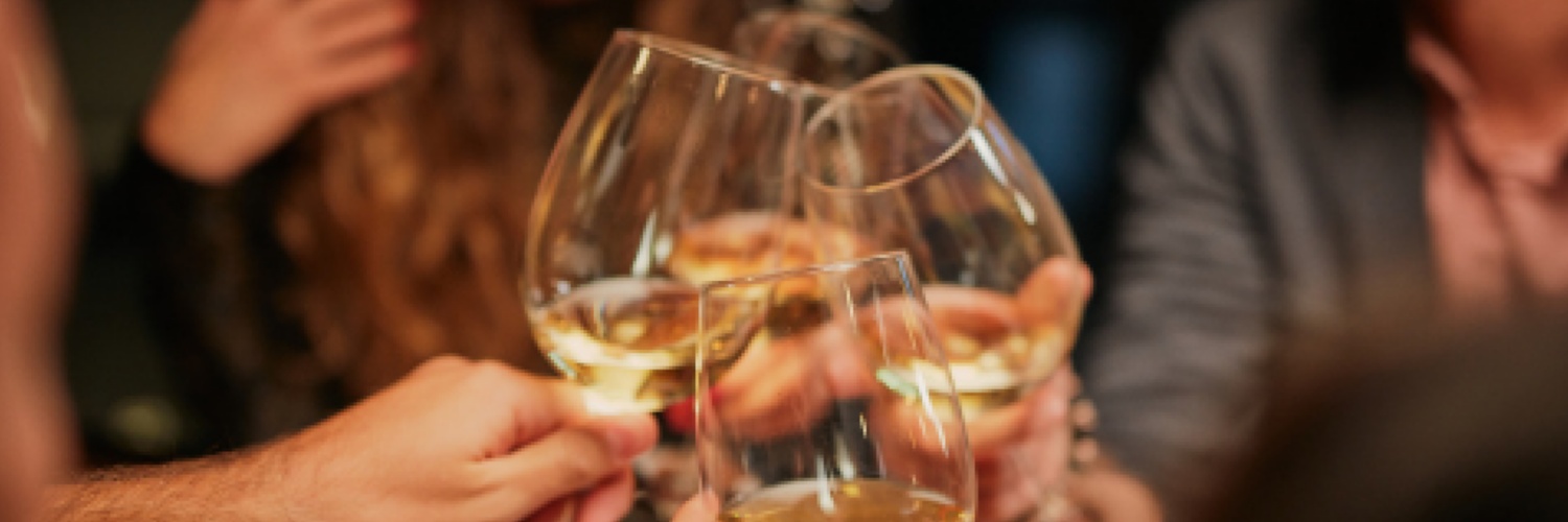 3 Gläser Weißweine auf einem Holztisch mit Weintrauben als Dekoration