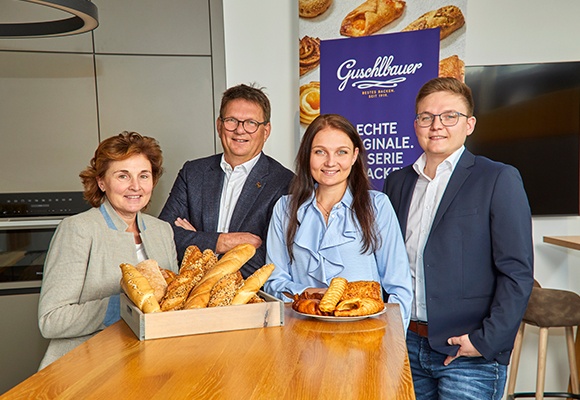 Familie Guschlbauer hinter einem Thresen mit Gebäckstücken vor sich