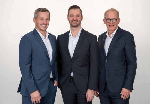 Zwei Herren halten gemeinsam einen großen Korb voll Brot und Gebäck