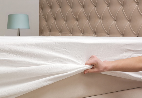 ROka napenja rjuho na posteljo