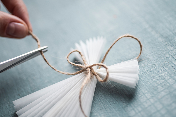 Masche wird um ein Papier gebunden