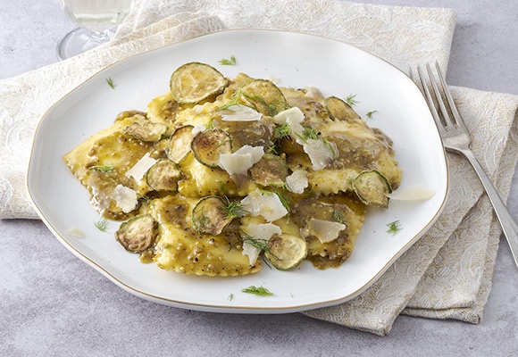Ravioli con crema di pistacchi e chips di zucchine