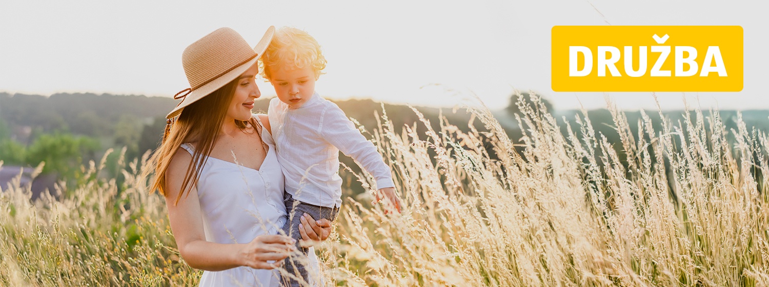 Mati v rokah drži otroka na žitnem polju