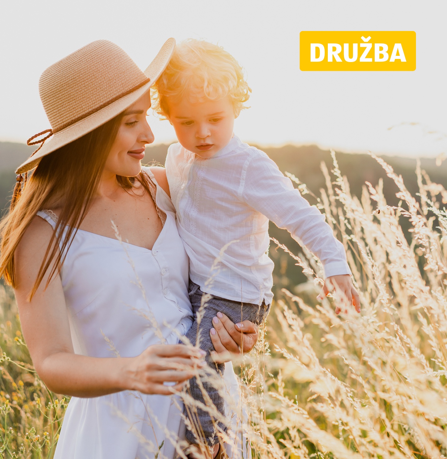 Mati v rokah drži otroka na žitnem polju