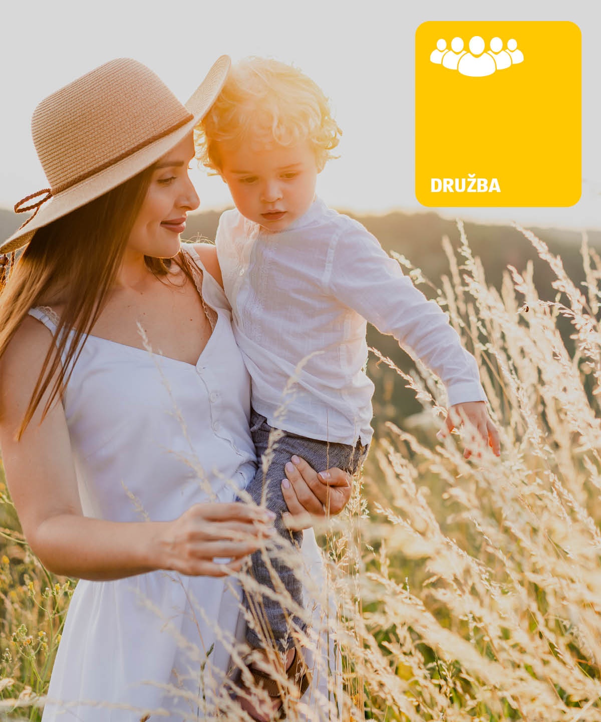 Ženska z otrokom v roki na travniku