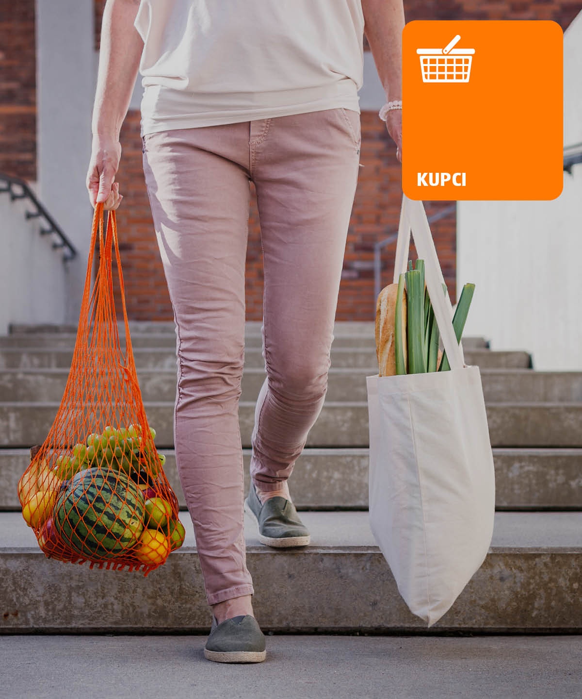 Ženska z dvema nakupovalnima vrečama v rokah, hodi po stopnicah