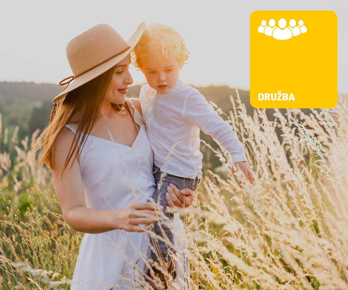 Ženska z otrokom v roki na travniku