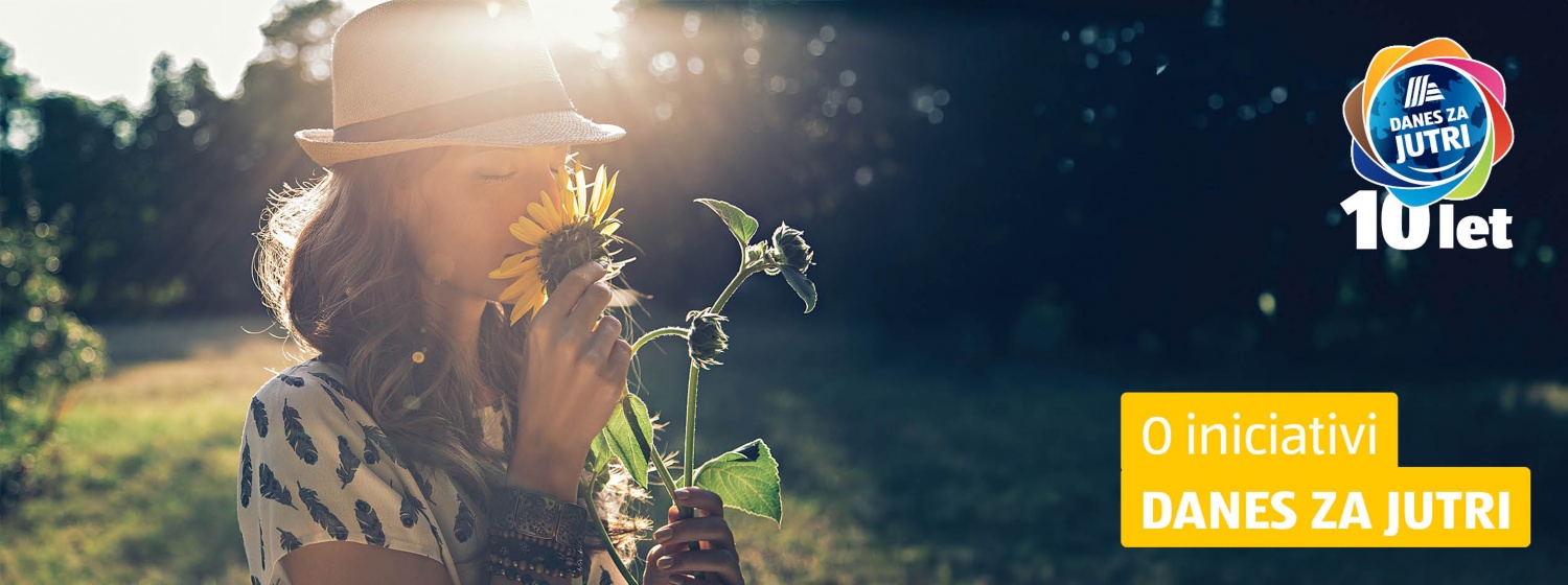 Ženska v naravi obsijana s soncem vonja sončnico