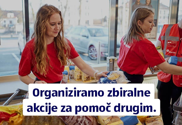 Hofer zaposleni v ozadju zlagajo darovane izdelke, Napis: Organiziramo zbiralne akcije za pomoč drugim.
