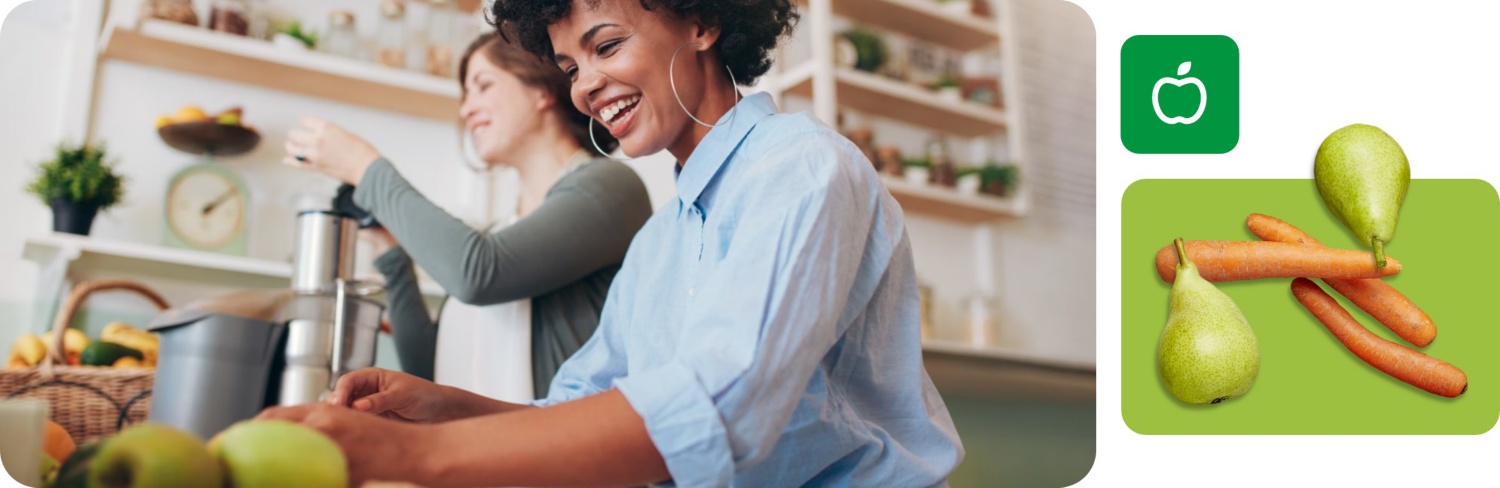Zwei Frauen entsaften in der Küche Obst und Gemüse für ihre Saftkur.