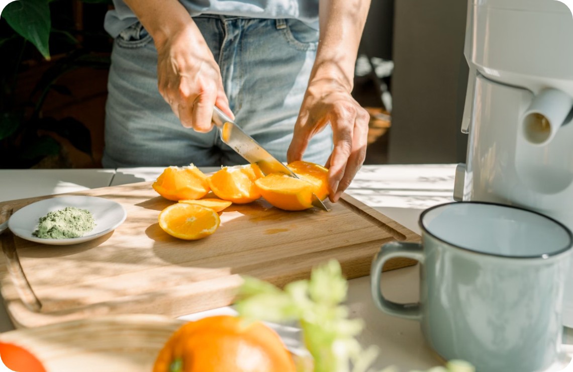 Eine Person schneidet frisches Obst auf einem Holzbrett