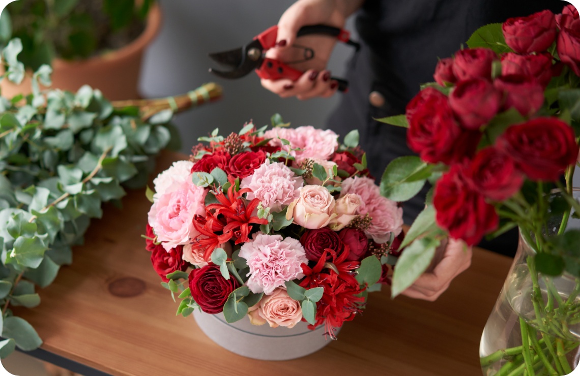 Fertig gestecktes Blumenarrangement aus rosa und roten Blumen.