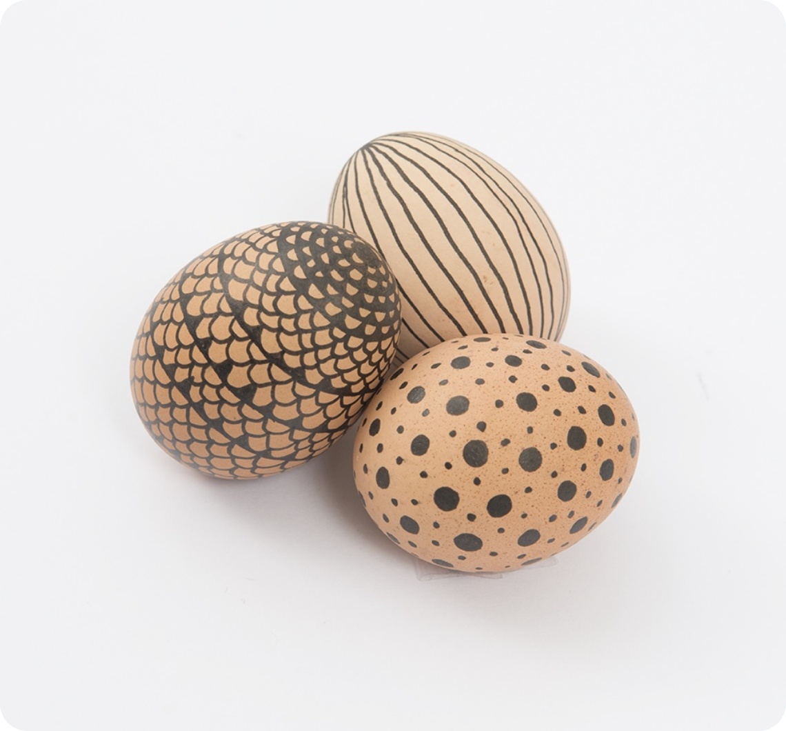 Braune Eier mit grafischen Mustern, die mit einem schwarzen Fineliner aufgetragen wurden.