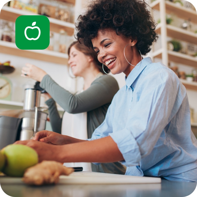 Zwei Frauen entsaften in der Küche Obst und Gemüse für ihre Saftkur.