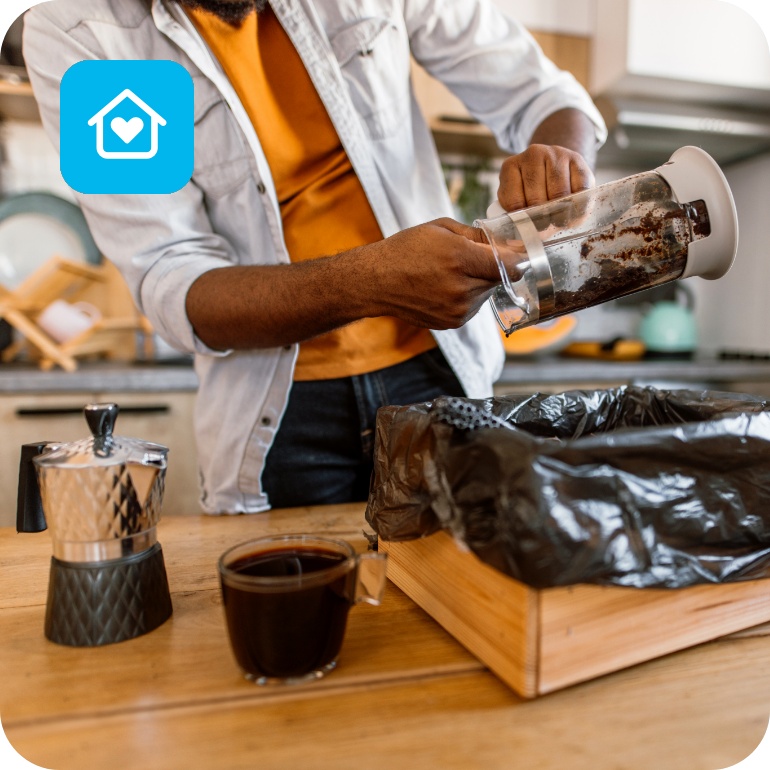 Eine Person löst den Kaffeesatz aus einer French Press zum Weiterverwenden.
