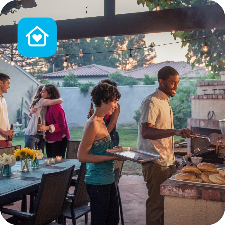 Eine Gruppe von Freunden bei einem Grillend mit Outdoorküche.