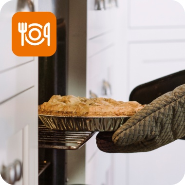 Eine Person holt einen frisch gebackenen glutenfreien Kuchen aus dem Ofen.