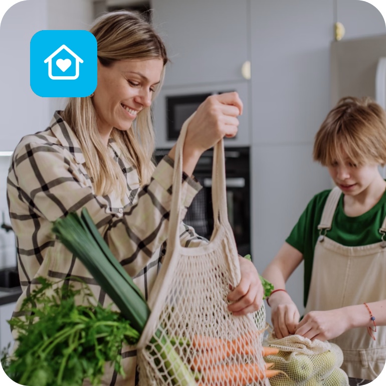 Mutter und Sohn packen Obst und Gemüse das sie eingekauft haben in der Küche aus.
