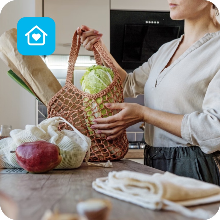 Eine Frau hält eine Tasche, gefüllt mit Gemüse.