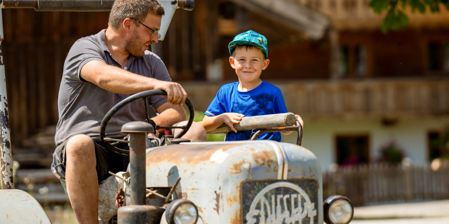 Florian Kreitmair mit Sohn auf Traktor.