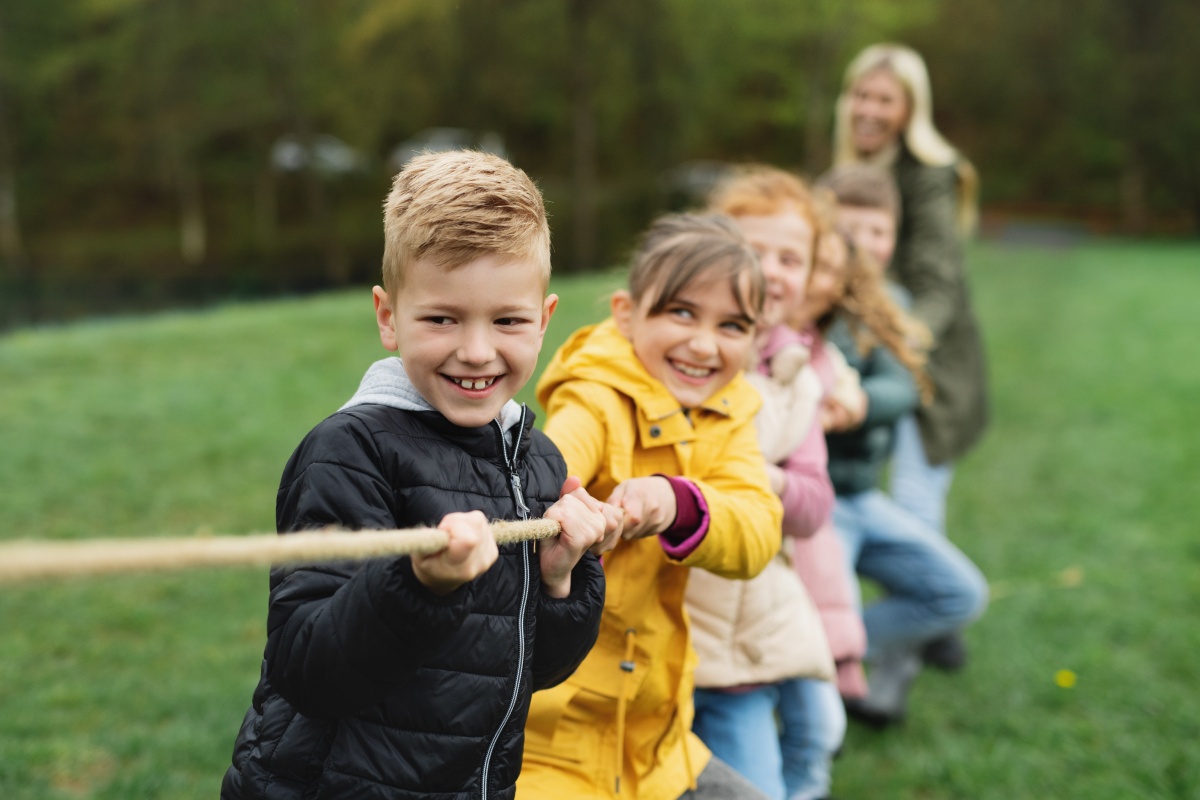 Kinder haben Spaß beim Tauziehen im Freien.