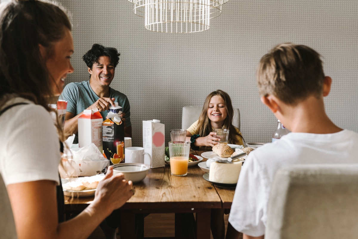 Familie genießt gemeinsam ein Frühstück am Tisch in der Küche. Ausgewogene Mahlzeit fördert bewusste Ernährung bei Kindern.