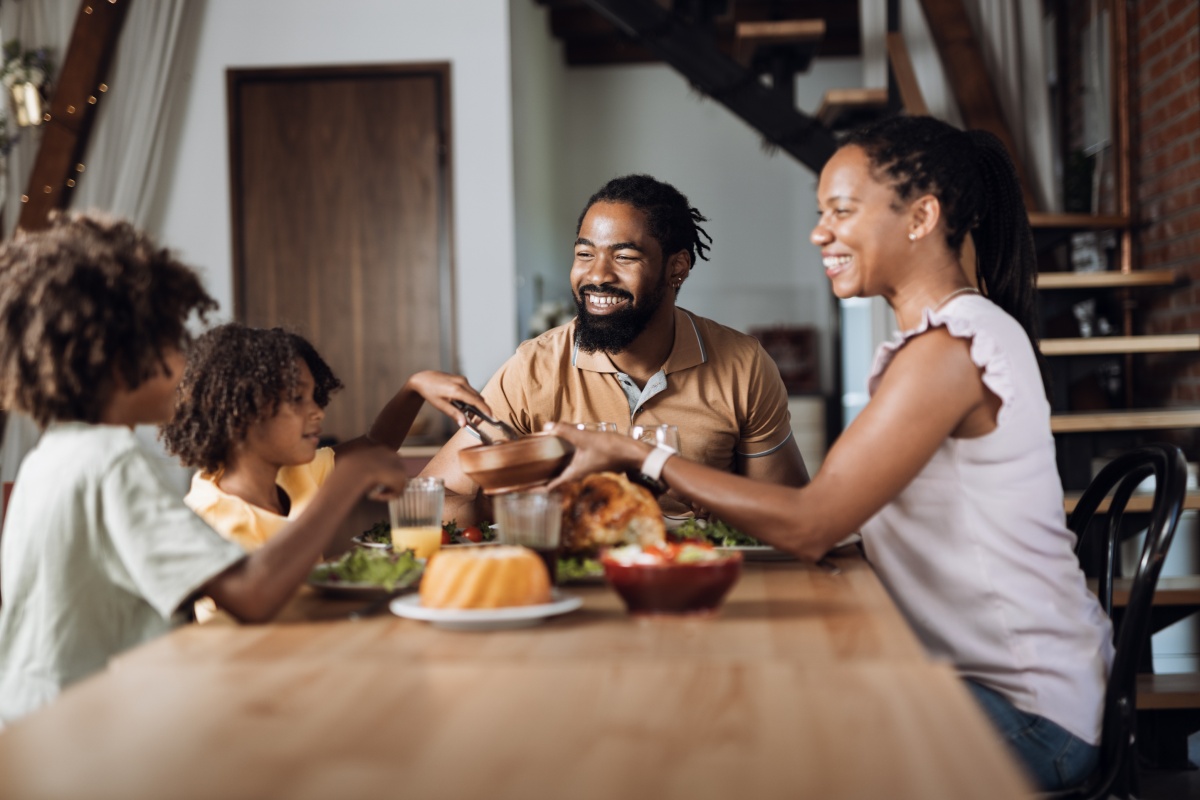 Familie sitzt gemeinsam am Tisch und genießt eine Mahlzeit. Gemeinsames.