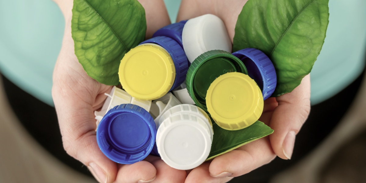 Zwei Hände voller Verschlusskappen.